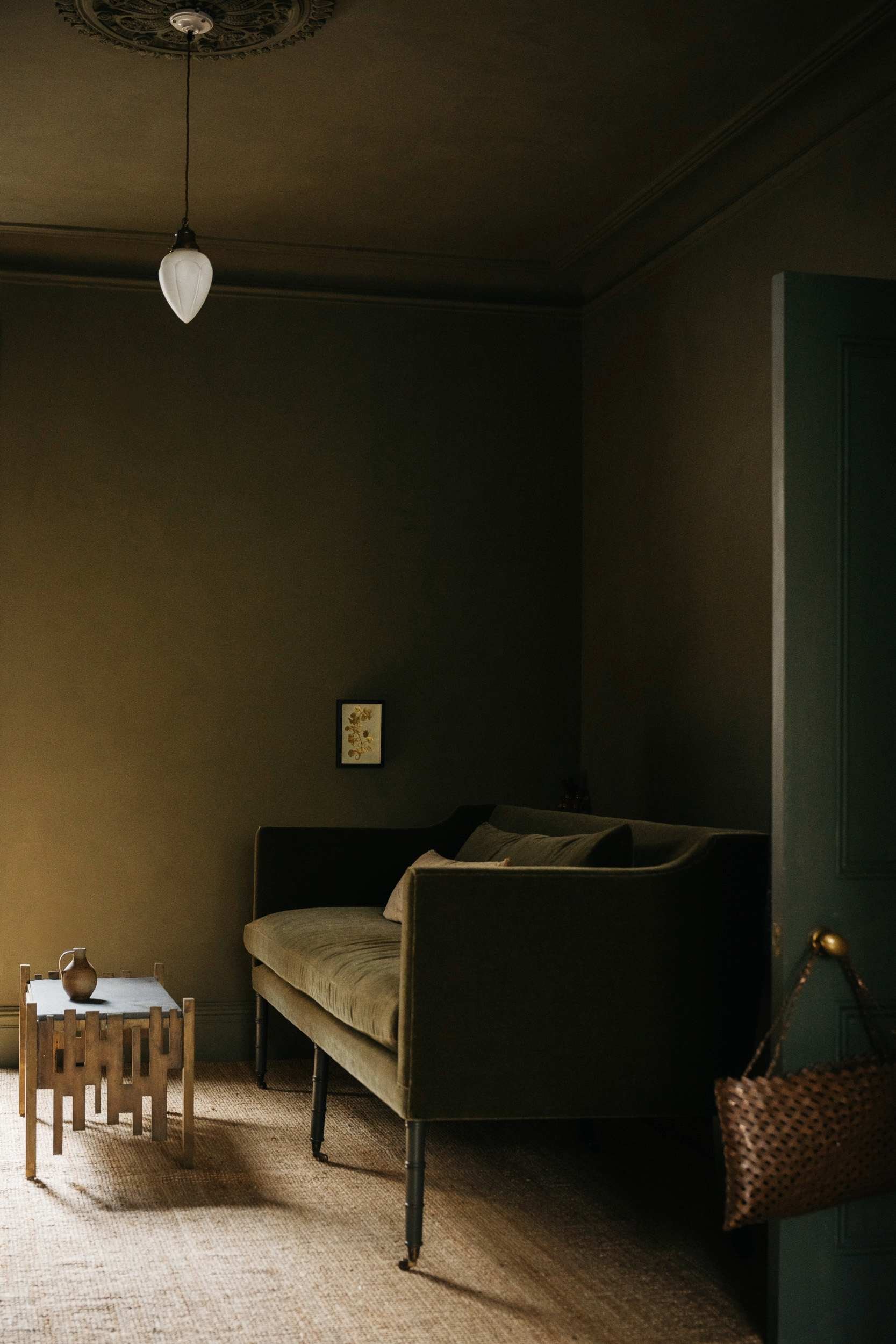 Living room painted in Atelier Ellis' Is-land, a sunlit olive green paint colour.