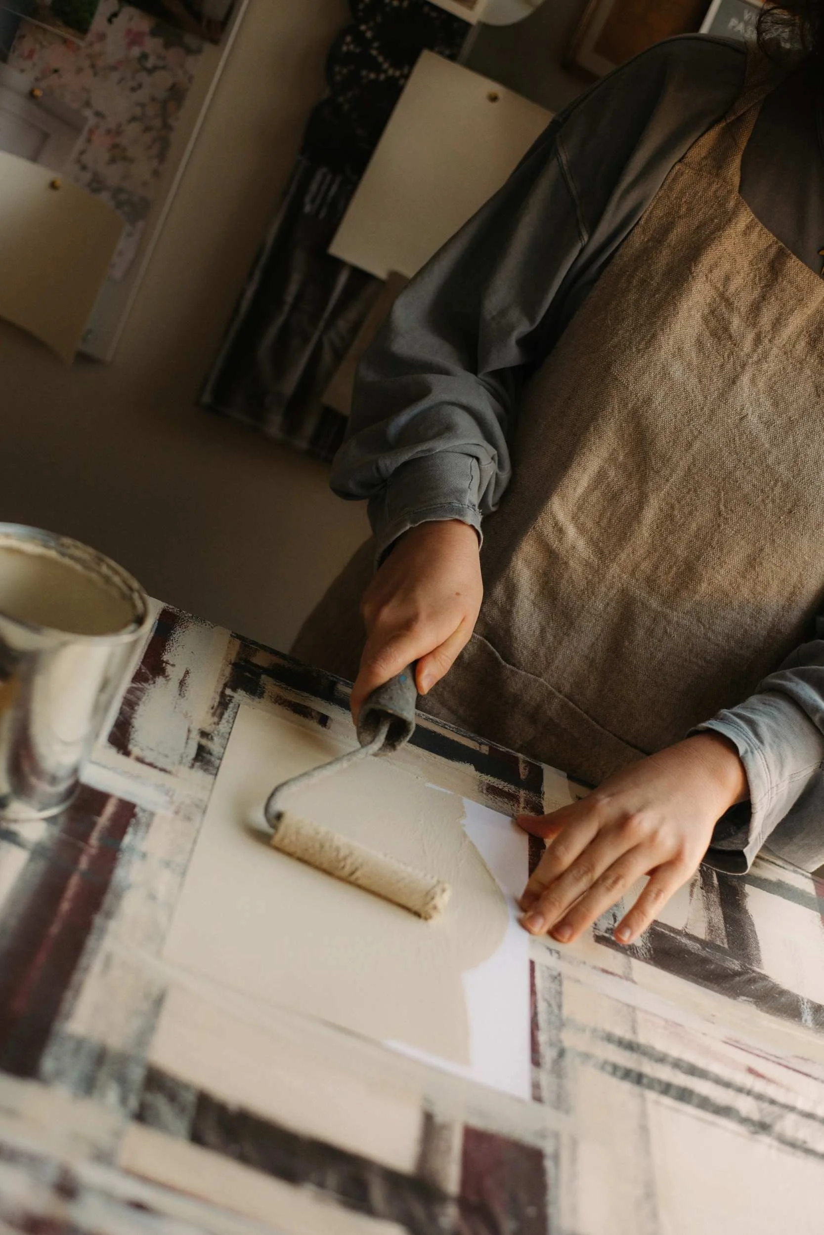 Atelier Ellis employee painting an A4 sample card of their colour Crumpet, a comforting warm neutral.