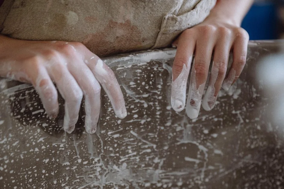 Employee with painty fingers looking over paint vat in which we mix our paint.