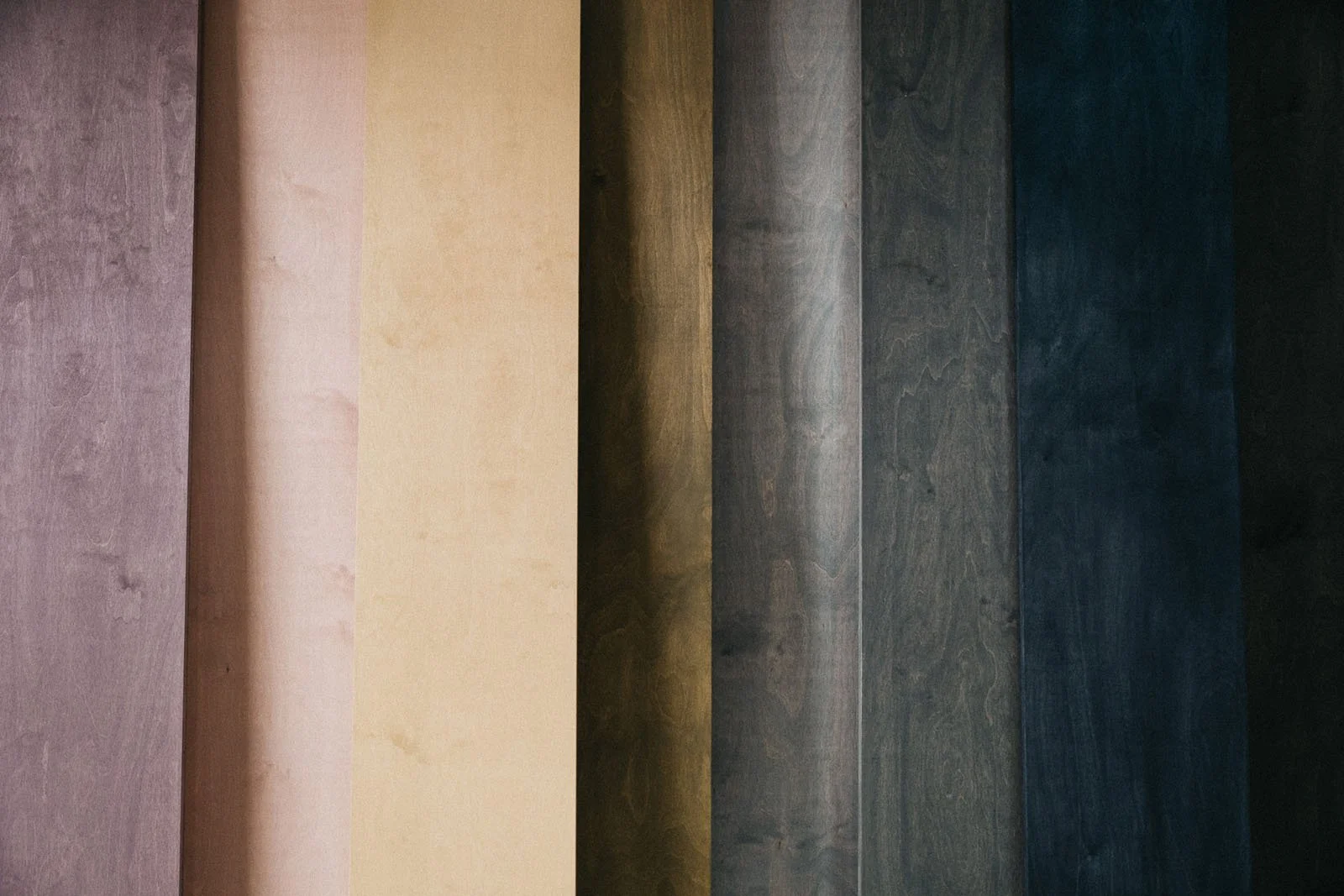 Coloured stains applied on 8 wooden boards.