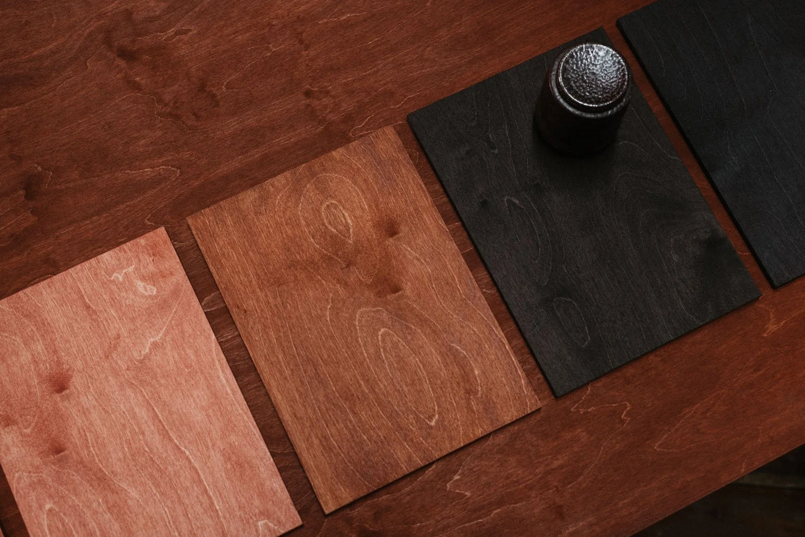 Stained A4 wooden sample boards laid on a table.