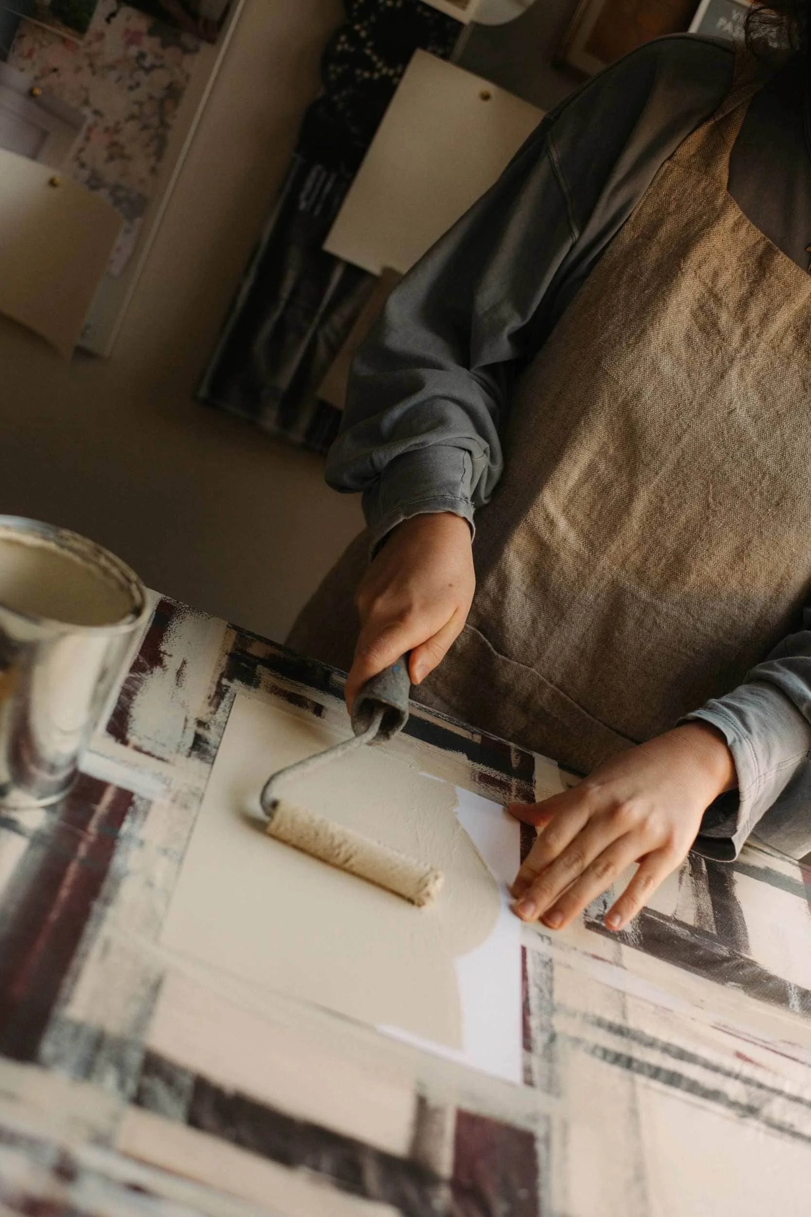 AE employee painting an A4 sample card with their bio-based paint using a roller brush.