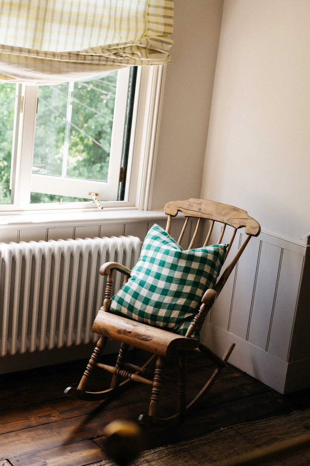 Rocking chair in the corner of a room at 'The Grove', Merchant & Mills' sewing residency. The wall and wooden panelling behind it are painted in Atelier Ellis Milk.