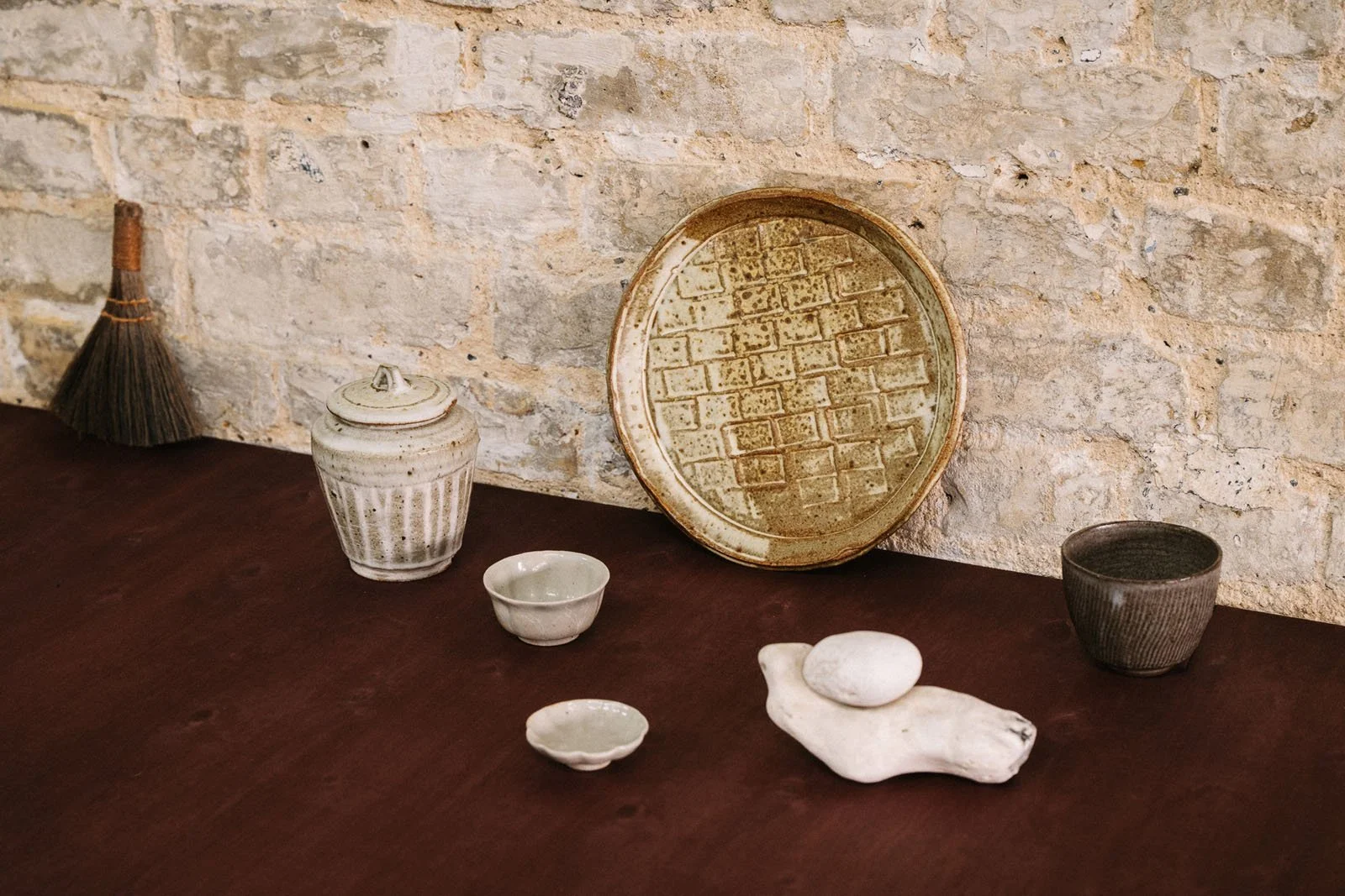 Decorative objects layered on a ruddy violet stained wooden surface