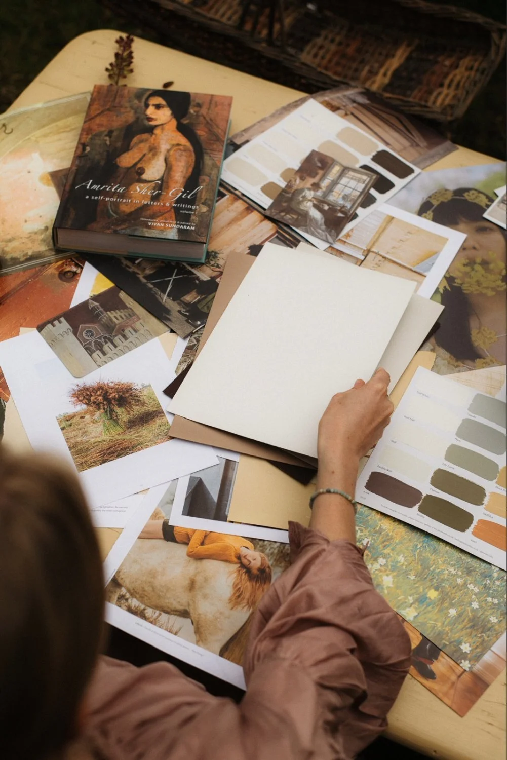 Women browsing Atelier Ellis colour sample cards and moodboard inspirations.