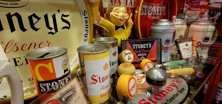 Vintage Stoney's Pilsener cans beside a Mr. Smoothie figure