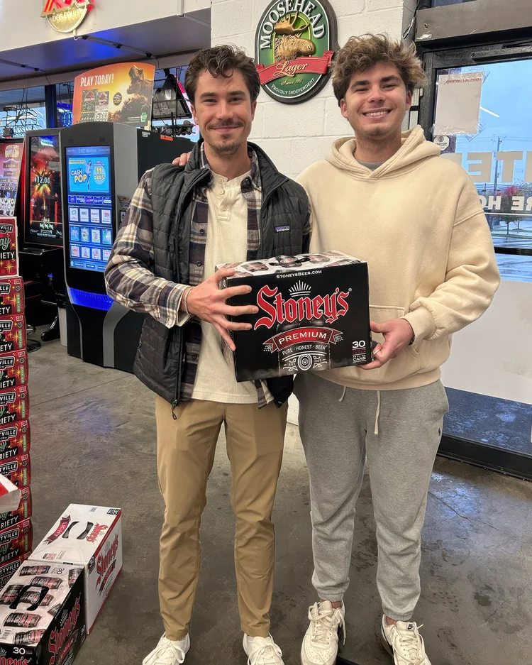 Two friends at a Stoney's Beer tasting event at Hampton Beer Outlet in Allison Park, Pennsylvania, holding a six-pack of Stoney's beer