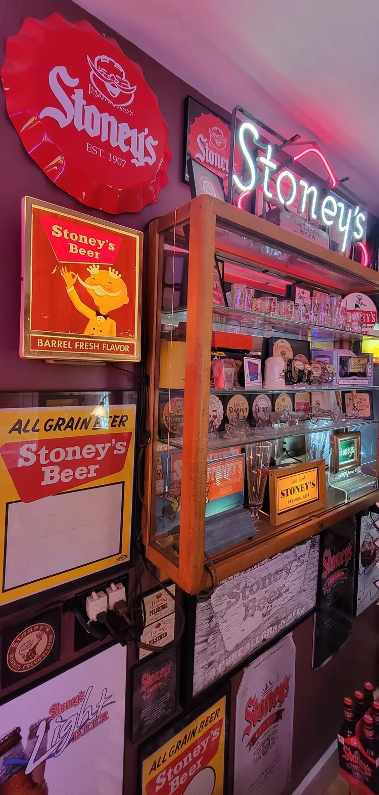 Wall of framed Stoney's signs with a Mr. Smoothie figure