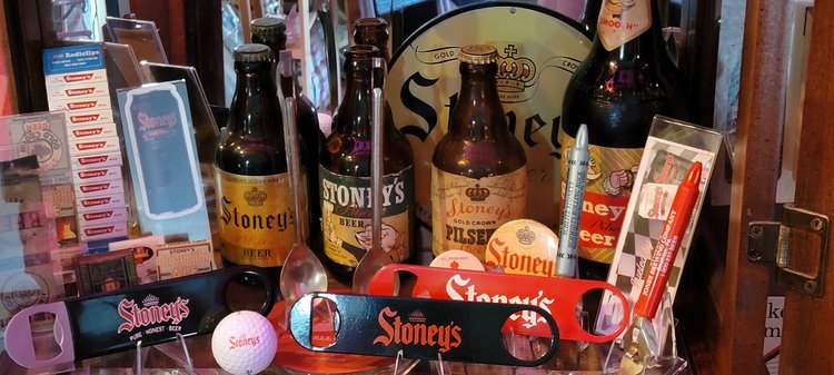 Vintage Stoney's bottles, cans, and a baseball on display
