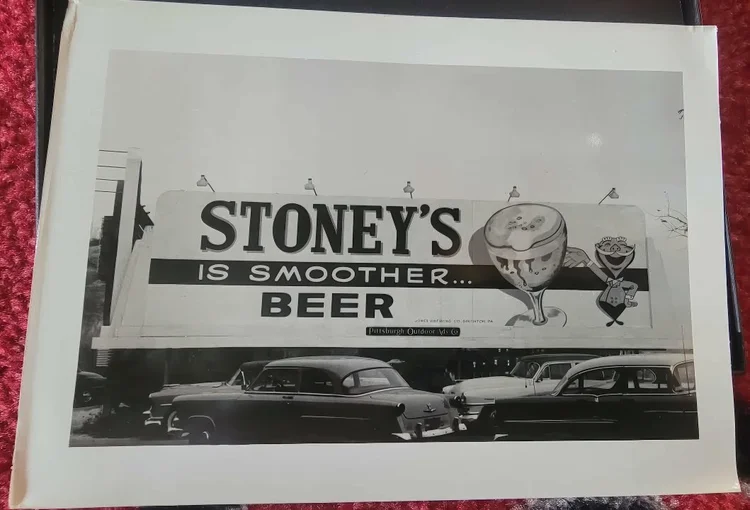 Black-and-white photo of a Stoney's Is Smoother Beer billboard