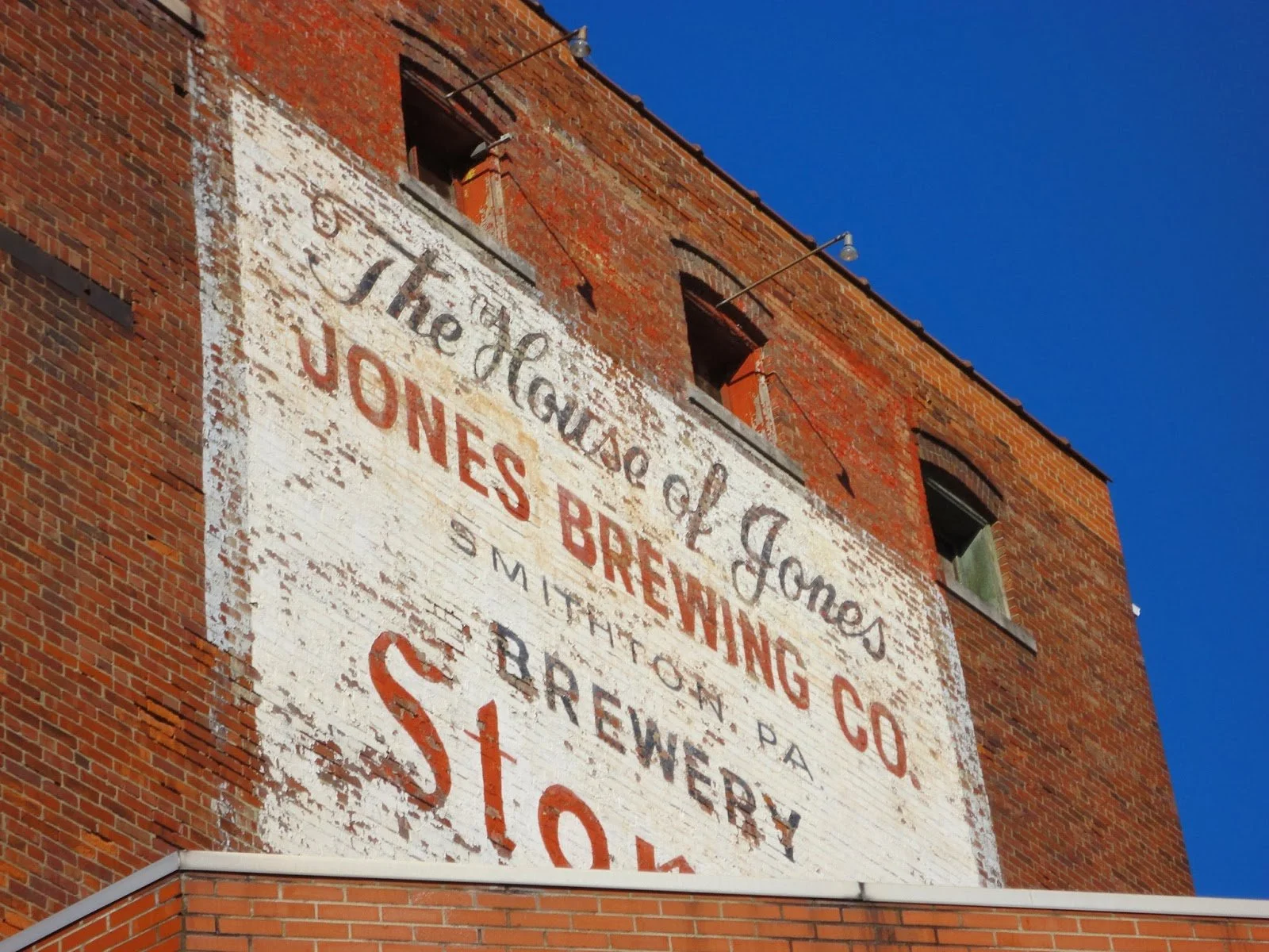 Close-up of the historic hand-painted Jones Brewing Company sign on the original brewery building in Smithton, Pennsylvania, reading The House of Jones, home of Stoney's Beer since 1907.