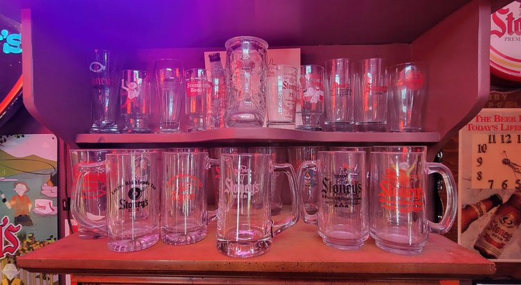 Row of vintage Stoney's glass beer mugs on a shelf