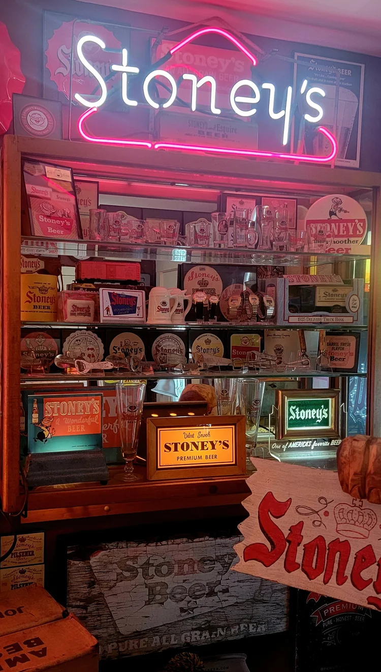 Stoney's neon sign over a lit shelf of advertising