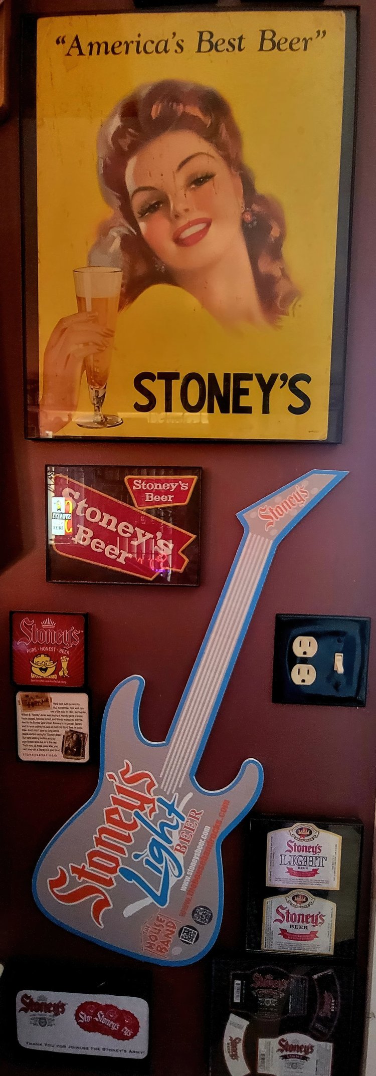 America's Best Beer Stoney's pin-up sign beside a guitar