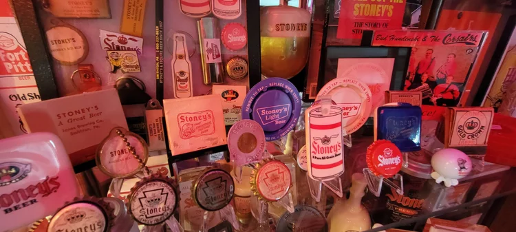 Shelf of vintage Stoney's Beer trays, bottle labels, and advertising signs