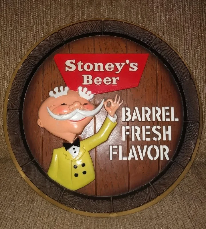 Round barrel sign reading Stoney's Barrel Fresh Flavor with a Mr. Smoothie figure