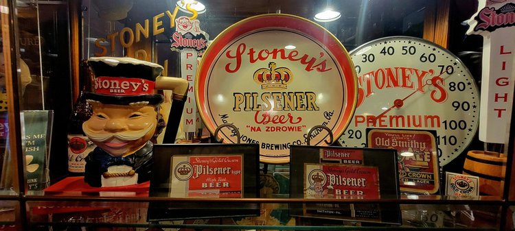 Lit Stoney's Electric Clock sign beside a Mr. Smoothie figure