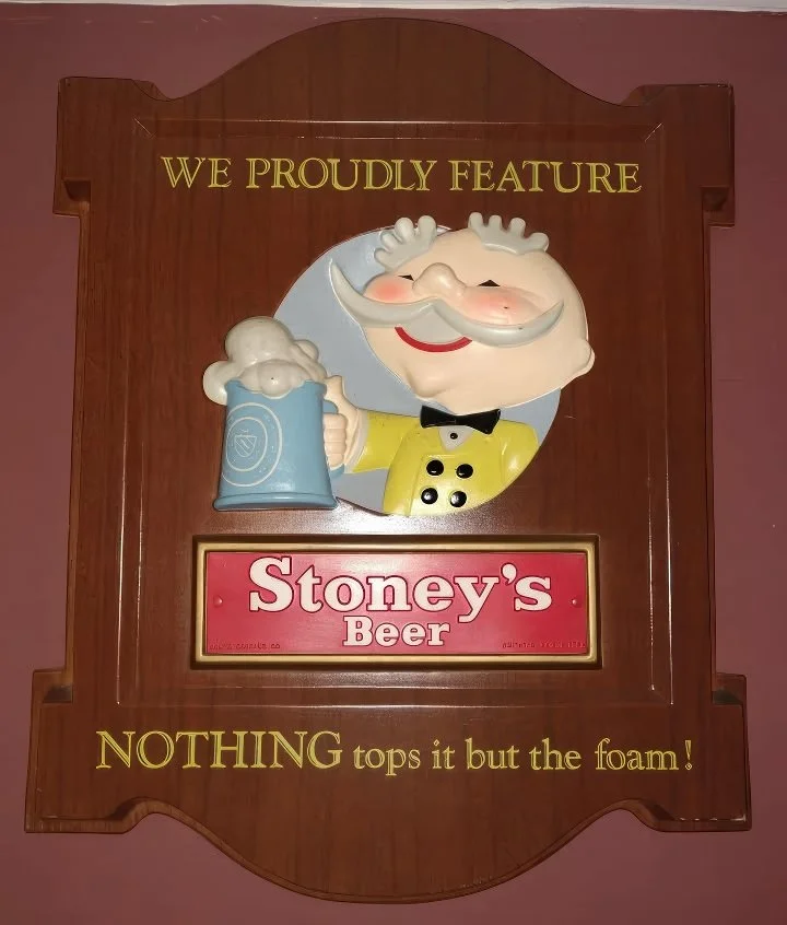 Wooden Stoney's sign reading Nothing Tops It But the Foam with a Mr. Smoothie figure