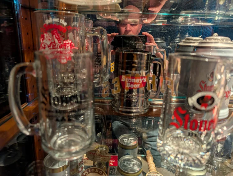 Vintage Stoney's Beer glass mugs and steins on a mirrored display shelf