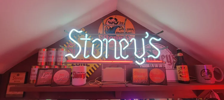 Stoney's neon sign over a lit shelf of advertising
