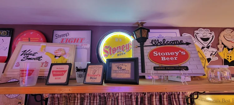 Shelf of framed Stoney's signs and lighted advertising pieces