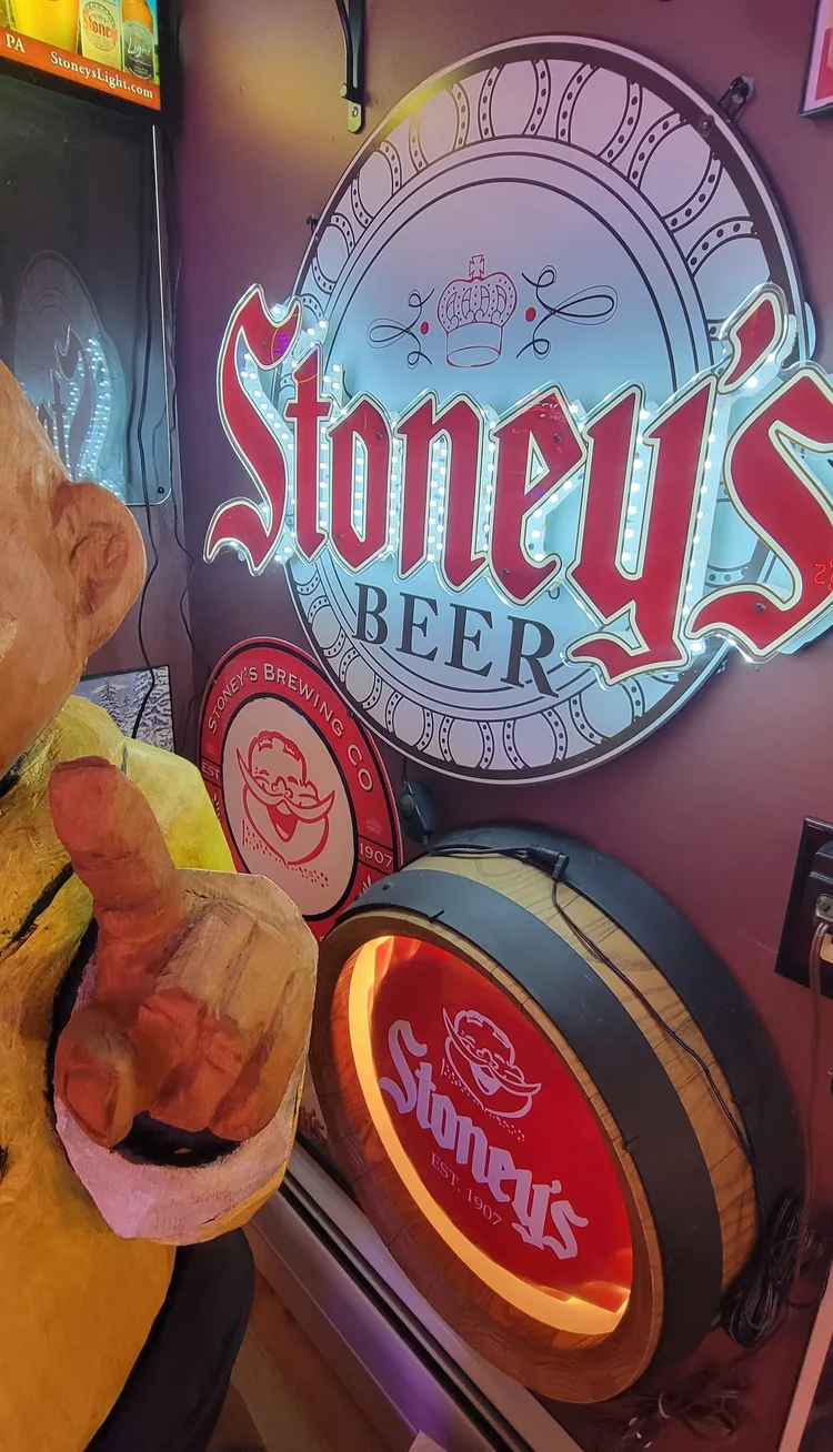 Large Stoney's Beer sign over a lit barrel display