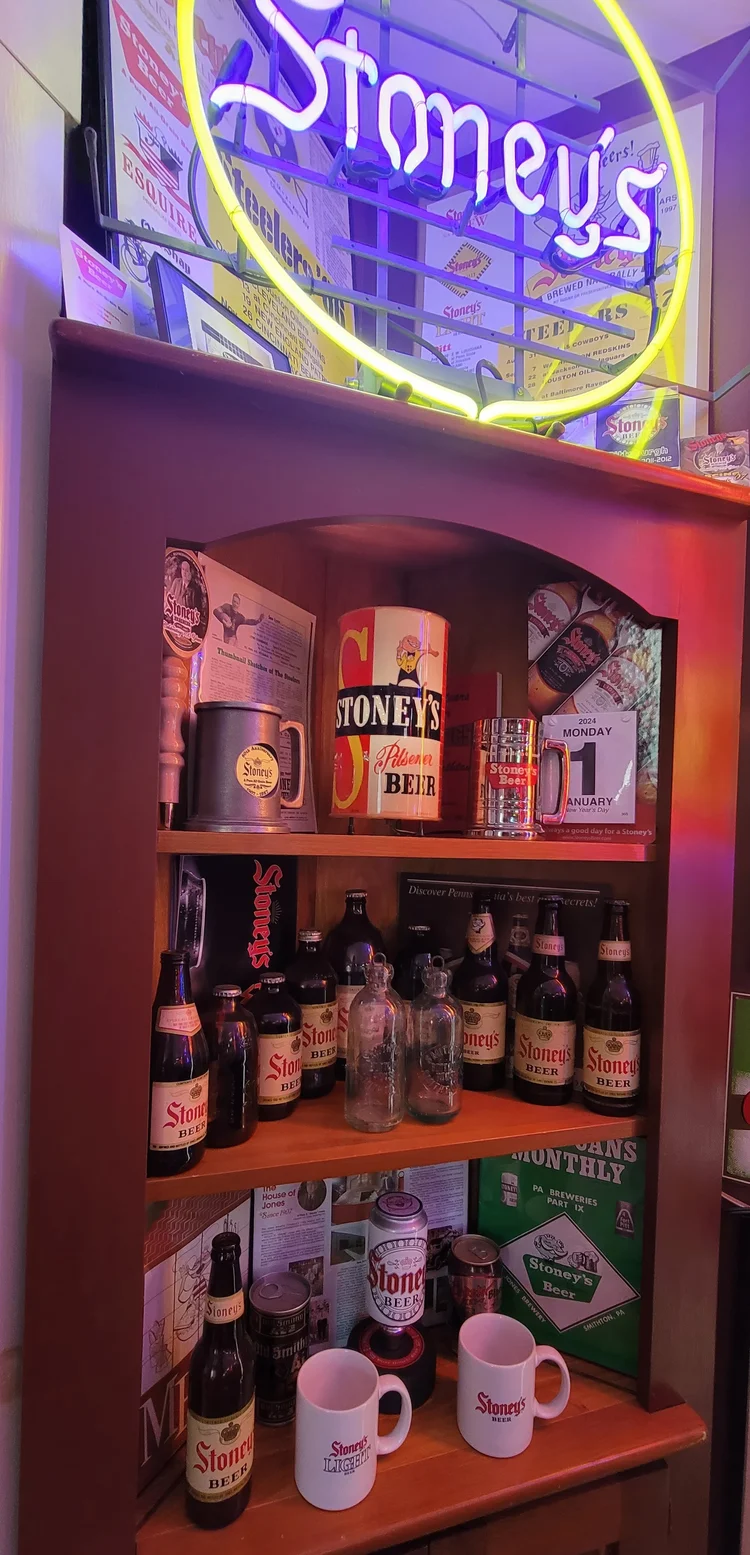 Round yellow Stoney's neon sign over a stocked shelf