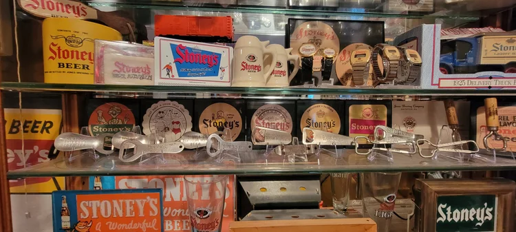 Shelf of vintage Stoney's coasters, labels, and signs