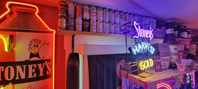 Vintage Stoney's neon sign and milk-can display lit in red