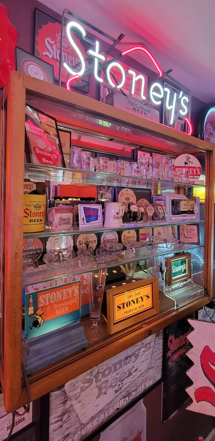 Stoney's neon sign above a packed shelf of advertising