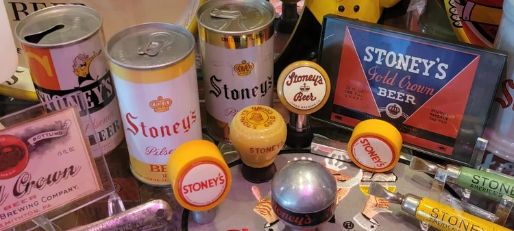 Vintage Stoney's cans, tap handles, and a lit Beer sign
