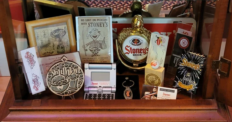 Framed Stoney's prints, a bottle lamp, and assorted advertising