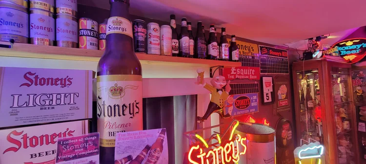 Stoney's lager bottle sign and neon advertising lit in red
