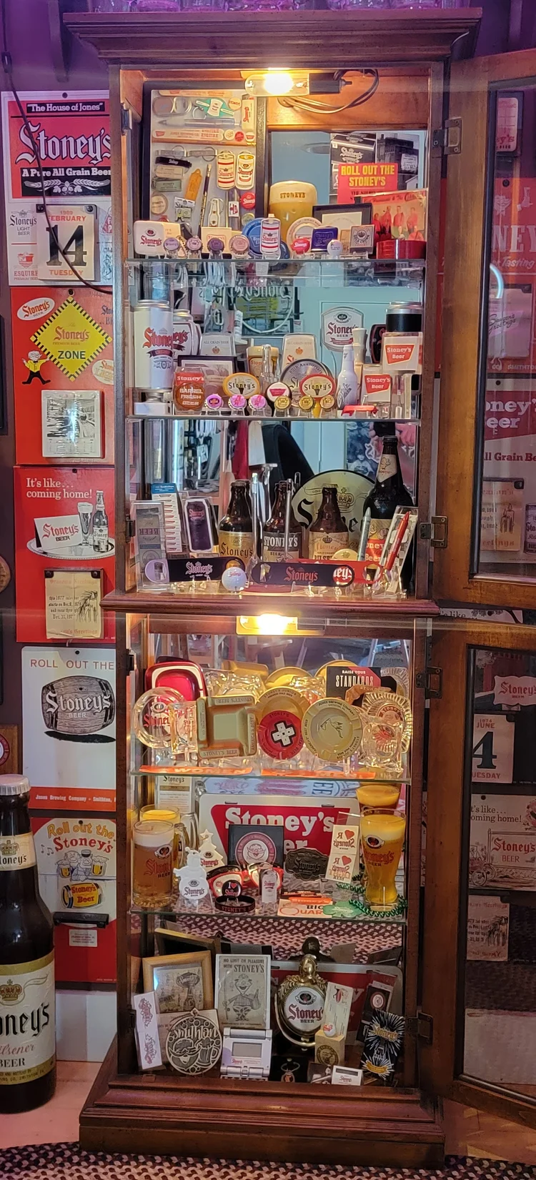 Tall lit case of Stoney's labels and small advertising