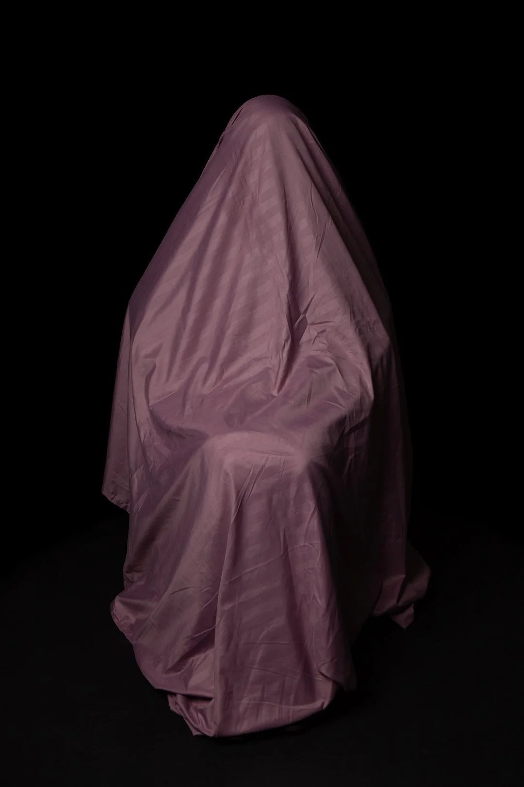 Colour photograph of a mother hidden beneath a draped piece of fabric produced by Clare Hughes Photography.
