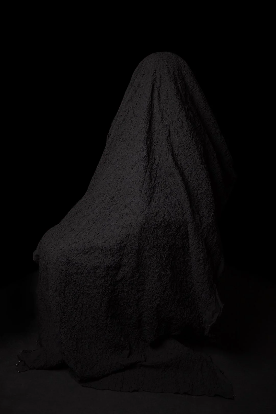 Colour photograph of a mother hidden beneath a draped piece of fabric produced by Clare Hughes Photography.