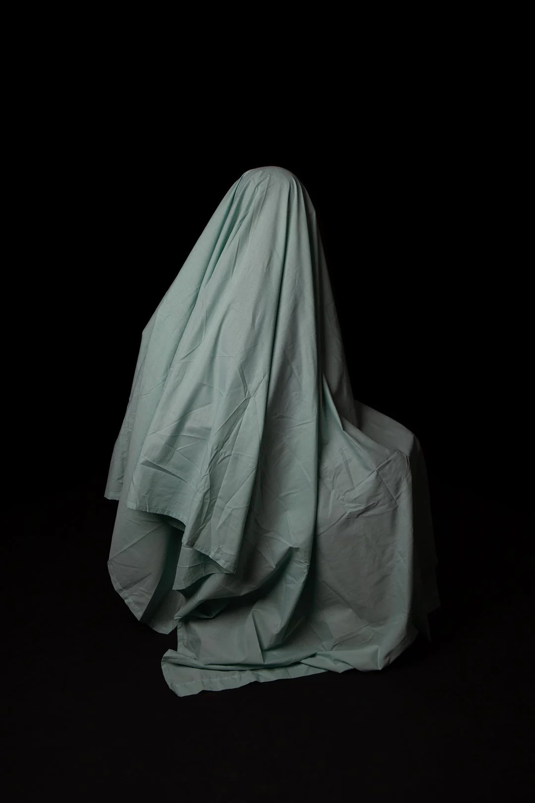 Colour photograph of a mother hidden beneath a draped piece of fabric produced by Clare Hughes Photography.