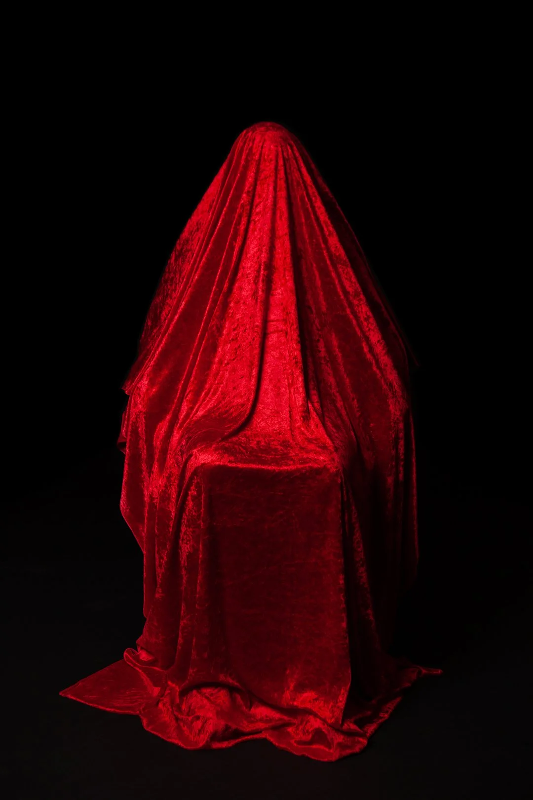 Colour photograph of a mother hidden beneath a draped piece of fabric produced by Clare Hughes Photography.