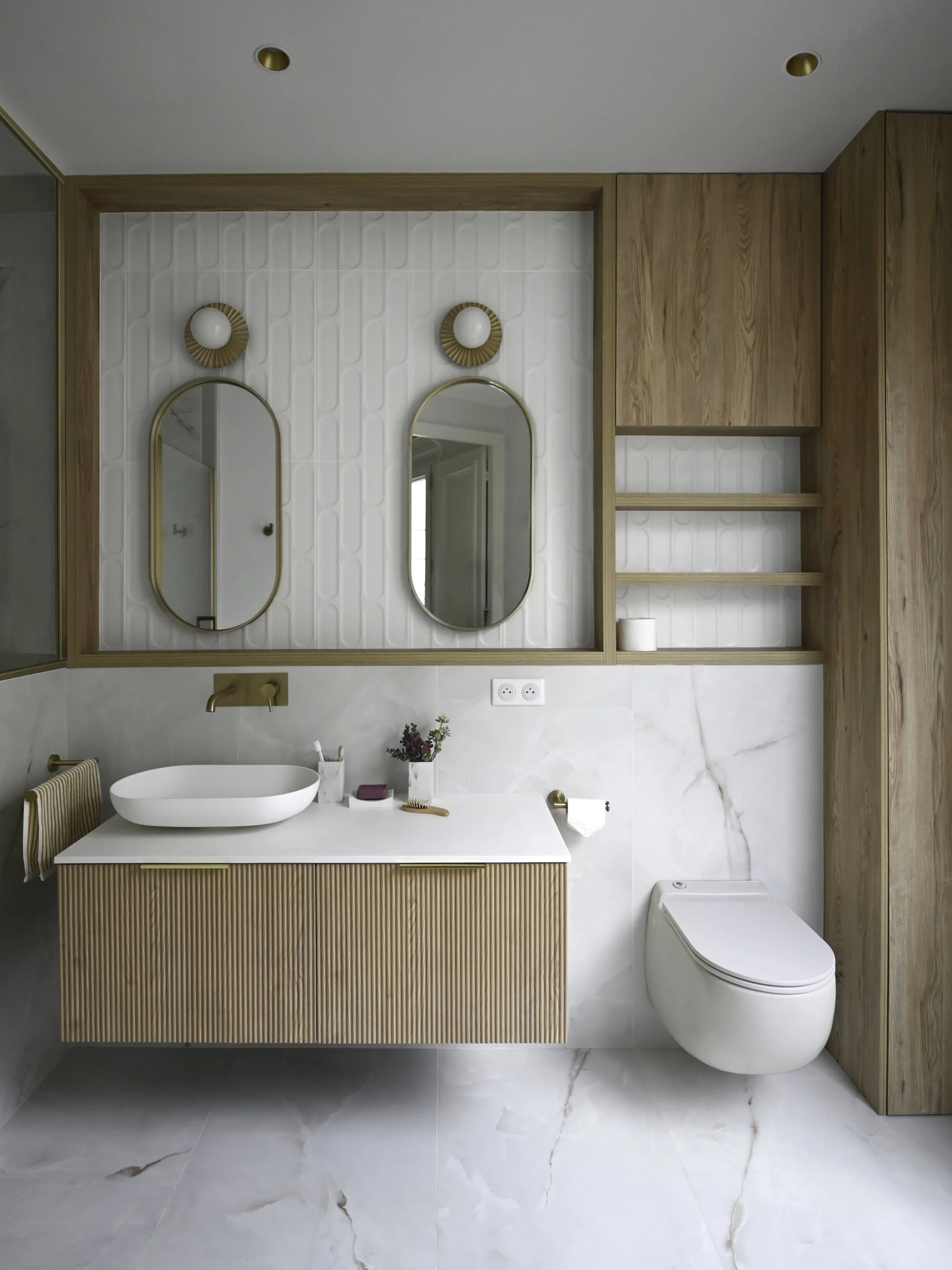 Salle de bain rénovée à Paris, association de bois clair et laiton