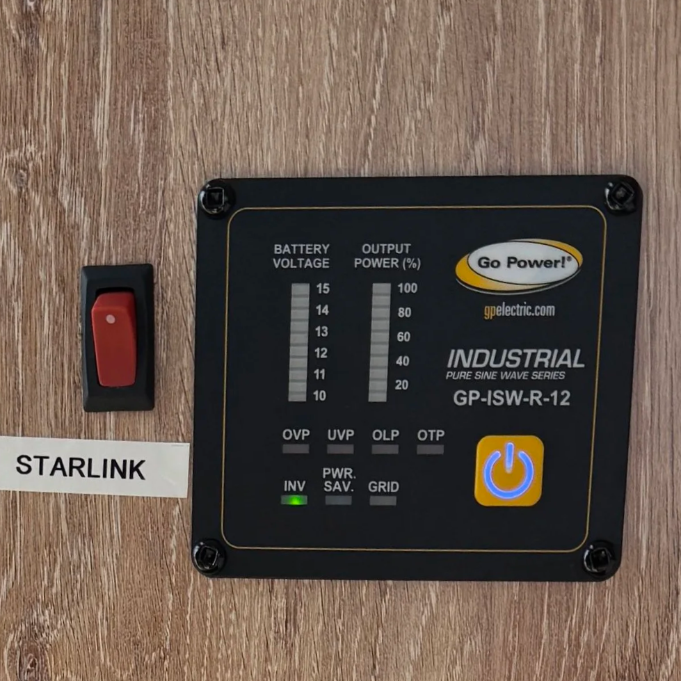 Blue Diversaew plastic container with a black cap, a vent, and a flexible black and silver hose, placed on a beige surface, with part of a window and window frame visible in the background.