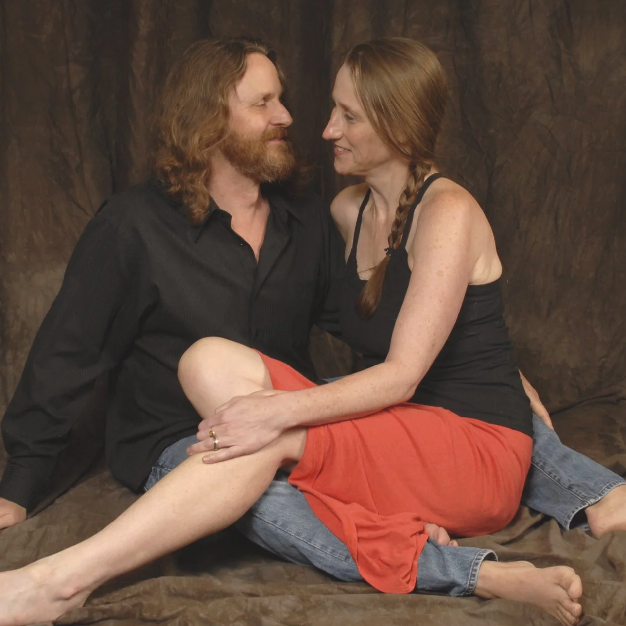 Independent authors Michael R. Swanson & Amanda K. King posing for author photos, looking at each other and giggling.