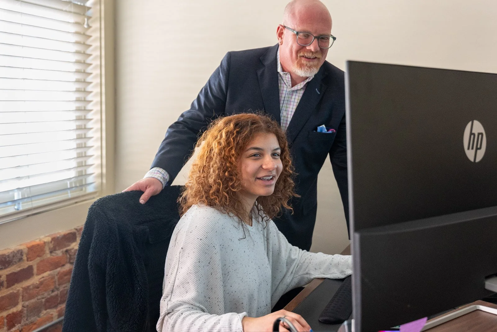 MoneyWise Payroll team members working together at a desk in the Charlottesville office