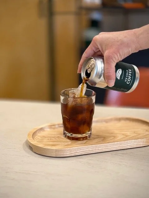 Pouring Nordskov can of coffee into a glass with ice