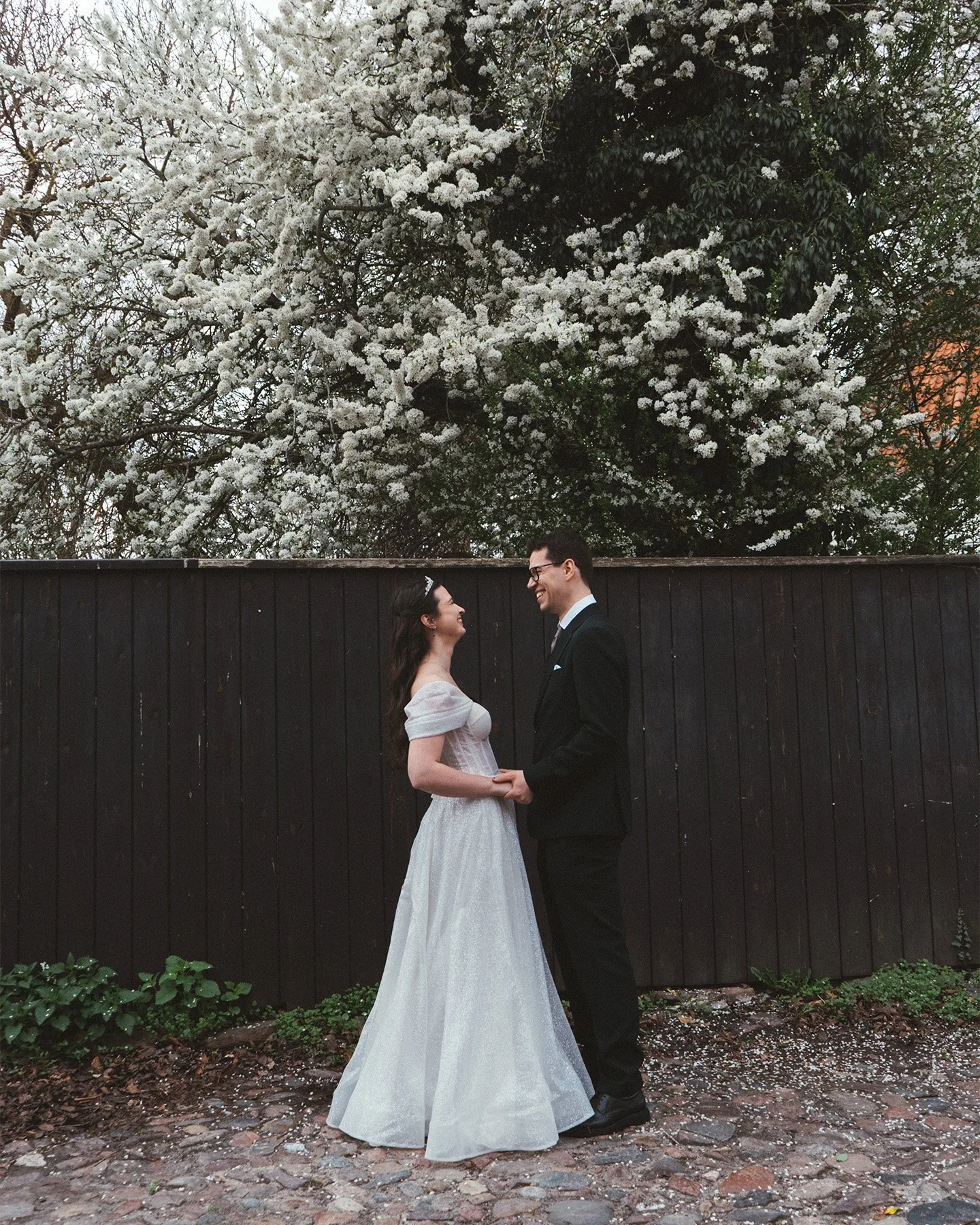 Bride and groom kissing in front of the historic red brick Copenhagen City Hall.