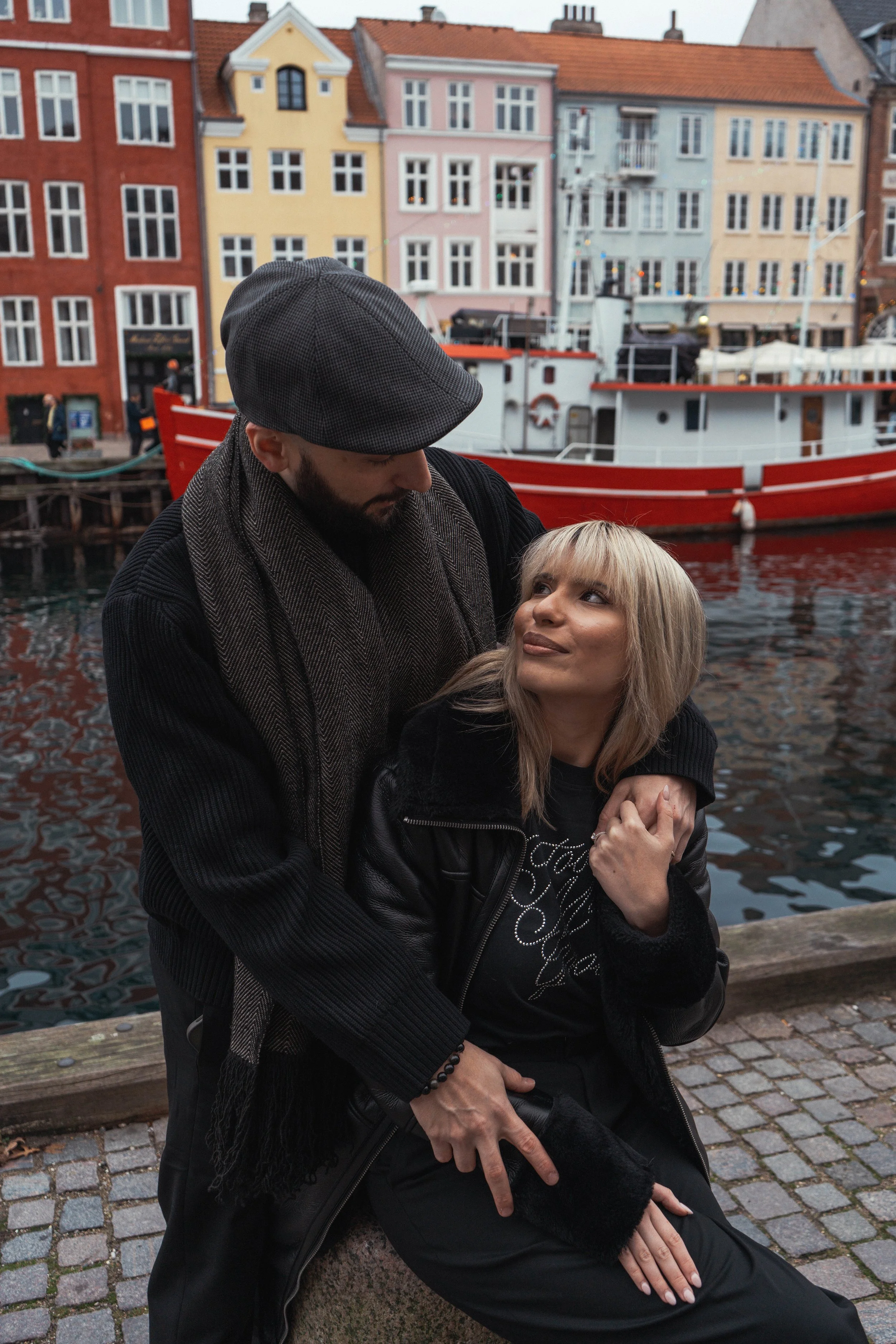 Tourist couples photography in Nyhavn, Copenhagen focused on natural connection rather than posed, traditional tourist photos.