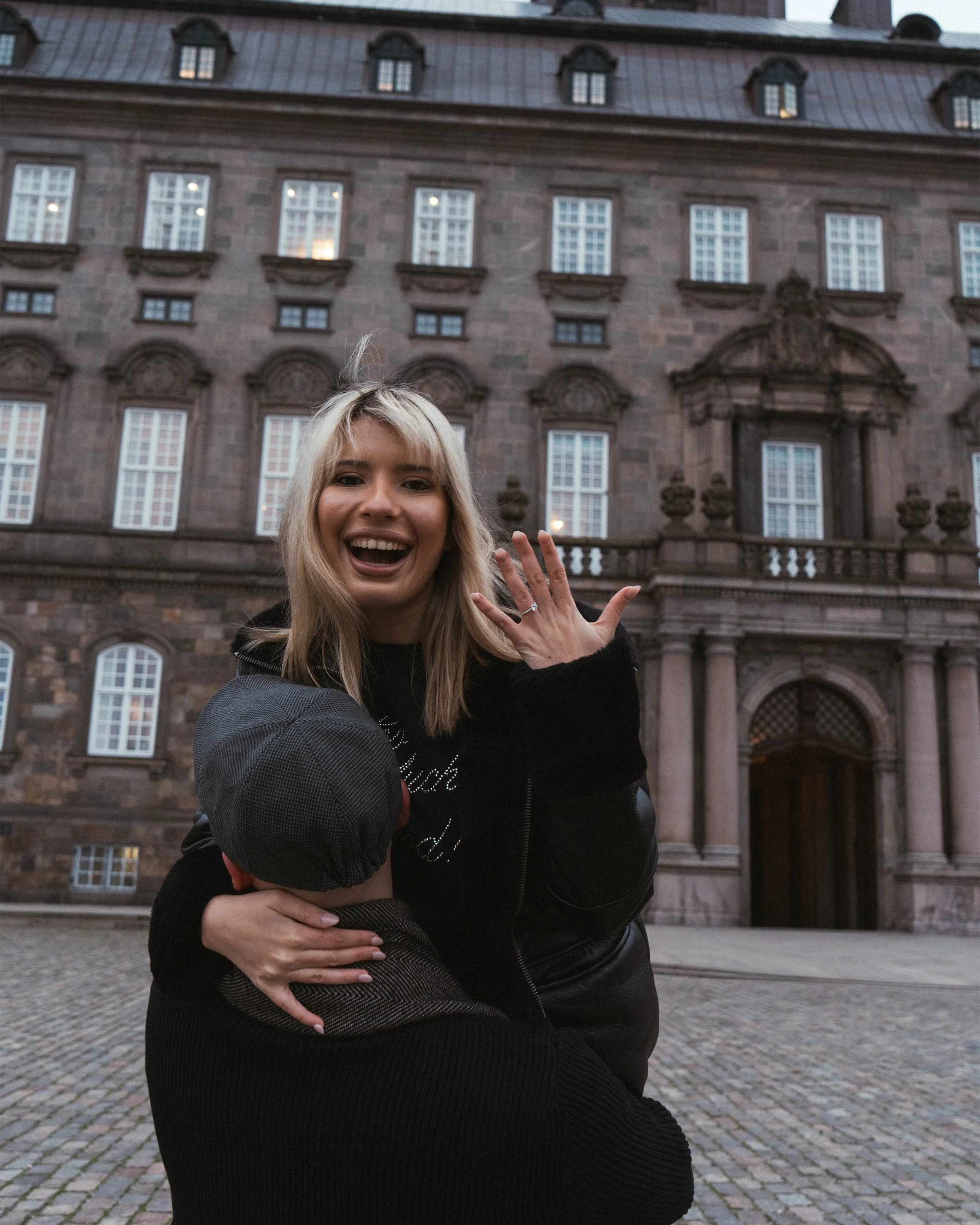 Couples portrait photography in Copenhagen at Christiansborg Palace featuring candid interaction and architectural atmosphere.