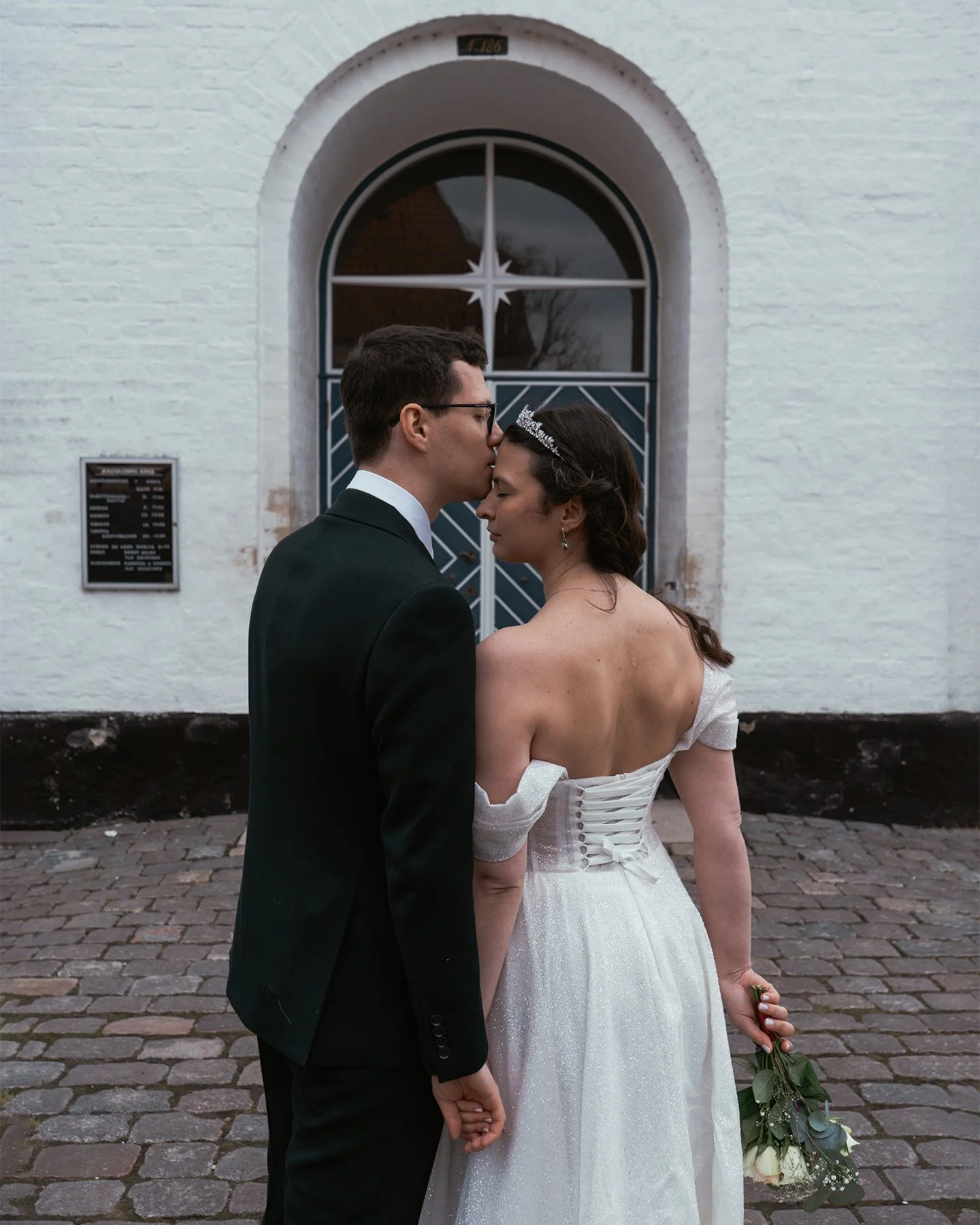 Couple exchanging rings under the glass ceiling of Copenhagen City Hall.