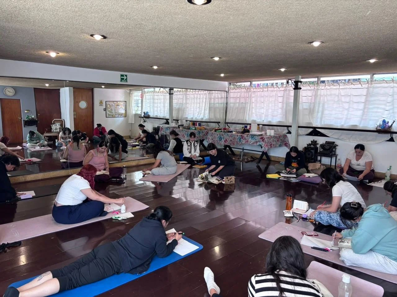 Grupo de personas participando en una clase de yoga en un ambiente interior.