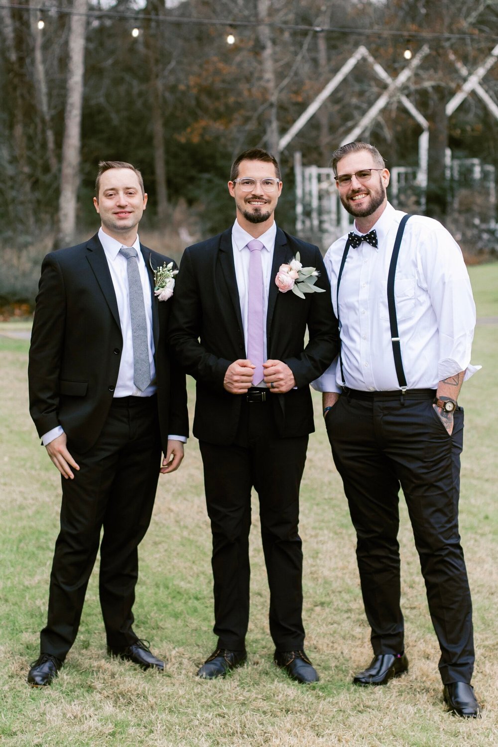  groom and groomsmen posed standing and smiling 