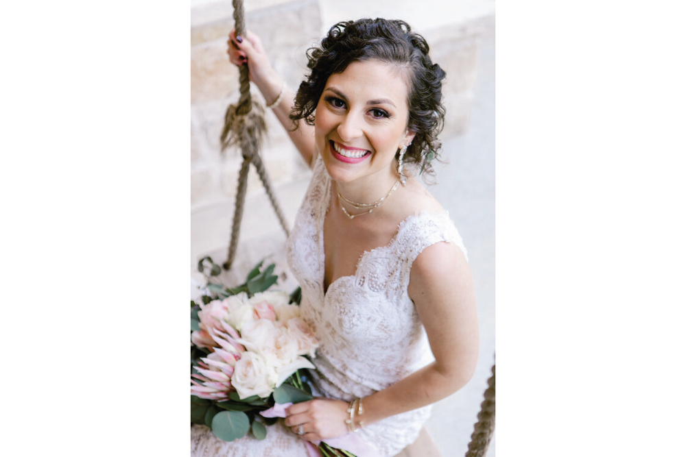  bride sitting on a swing. photo cropped vertically. 